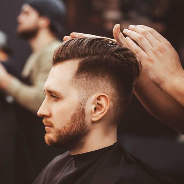 Barber styling a man's haircut