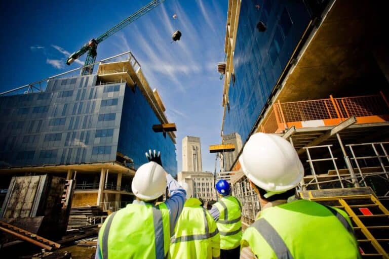 Construction site with high-rise buildings and workers in safety gear, promoting commercial construction insurance.