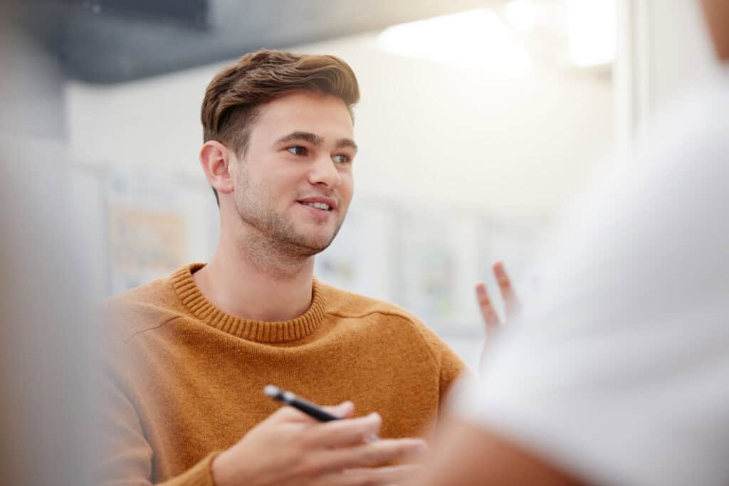 Young man engaging with insurance broker, discussing coverage options at Jensten Insurance Brokers in the UK.