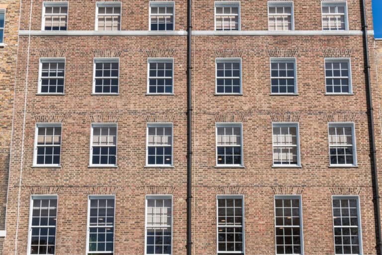 Modern brick building with multiple windows, representing commercial property insurance solutions.