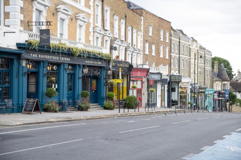 Colourful street view of local pubs and shops in a historic town centre, showcasing community and small business in the UK.