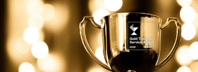 Golden award trophy reflecting lights, symbolising excellence in insurance brokerage services.