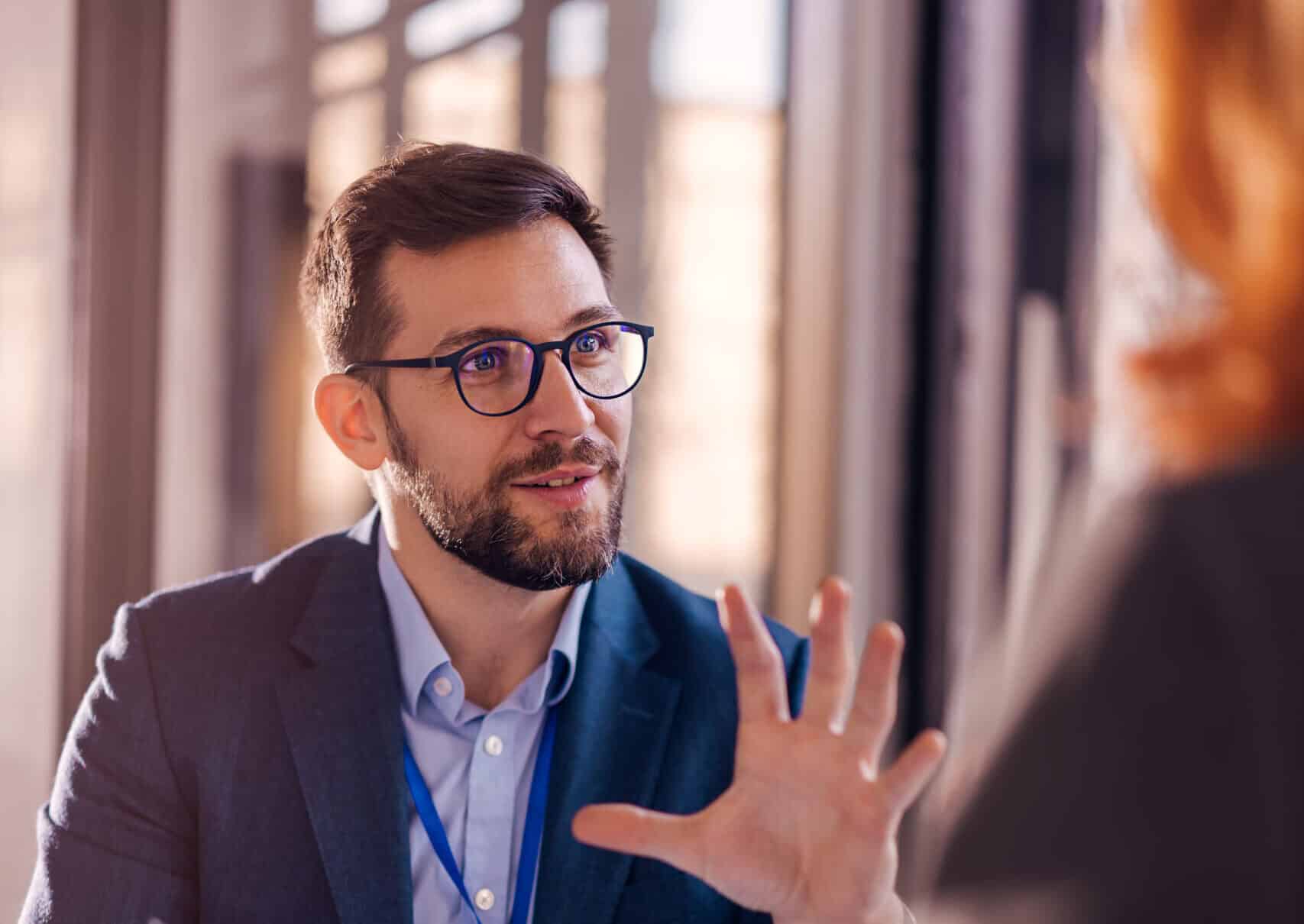 Professional insurance broker discussing coverage options with client at office.