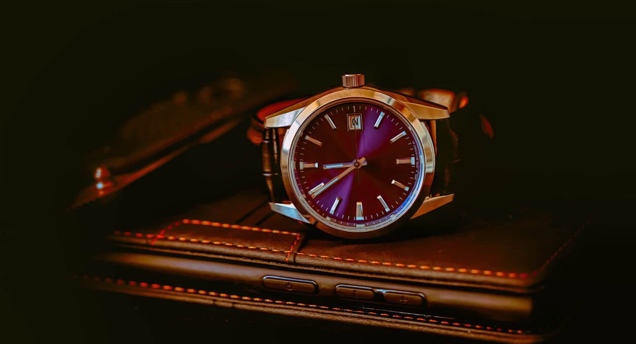 Luxury wristwatch on leather wallet, emphasizing timepiece investment and style.