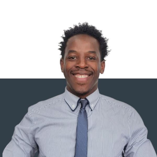 Professional insurance broker smiling in business attire, representing Jensten Insurance Brokers UK.