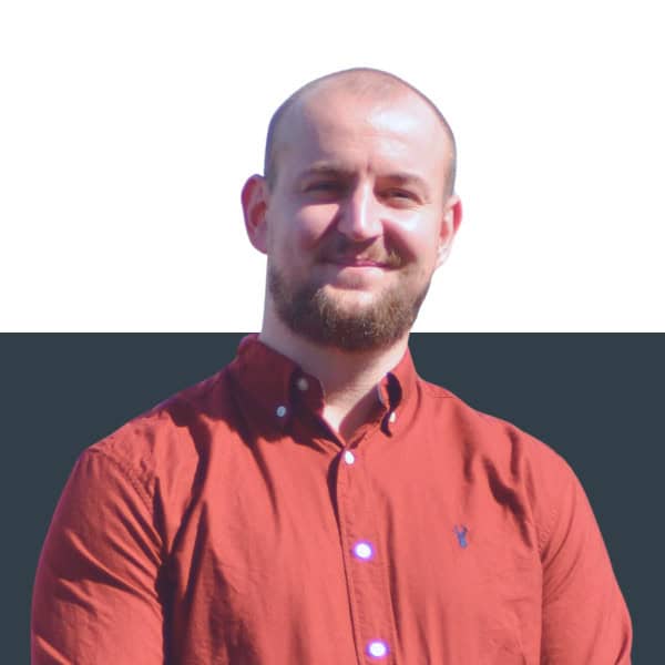 Professional insurance broker smiling outdoors in sunlight in the UK, expert in bespoke insurance solutions.