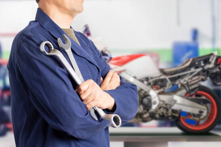 Wrench and mechanic in workshop with motorcycle, auto repair, vehicle insurance, Jensten Insurance Brokers.