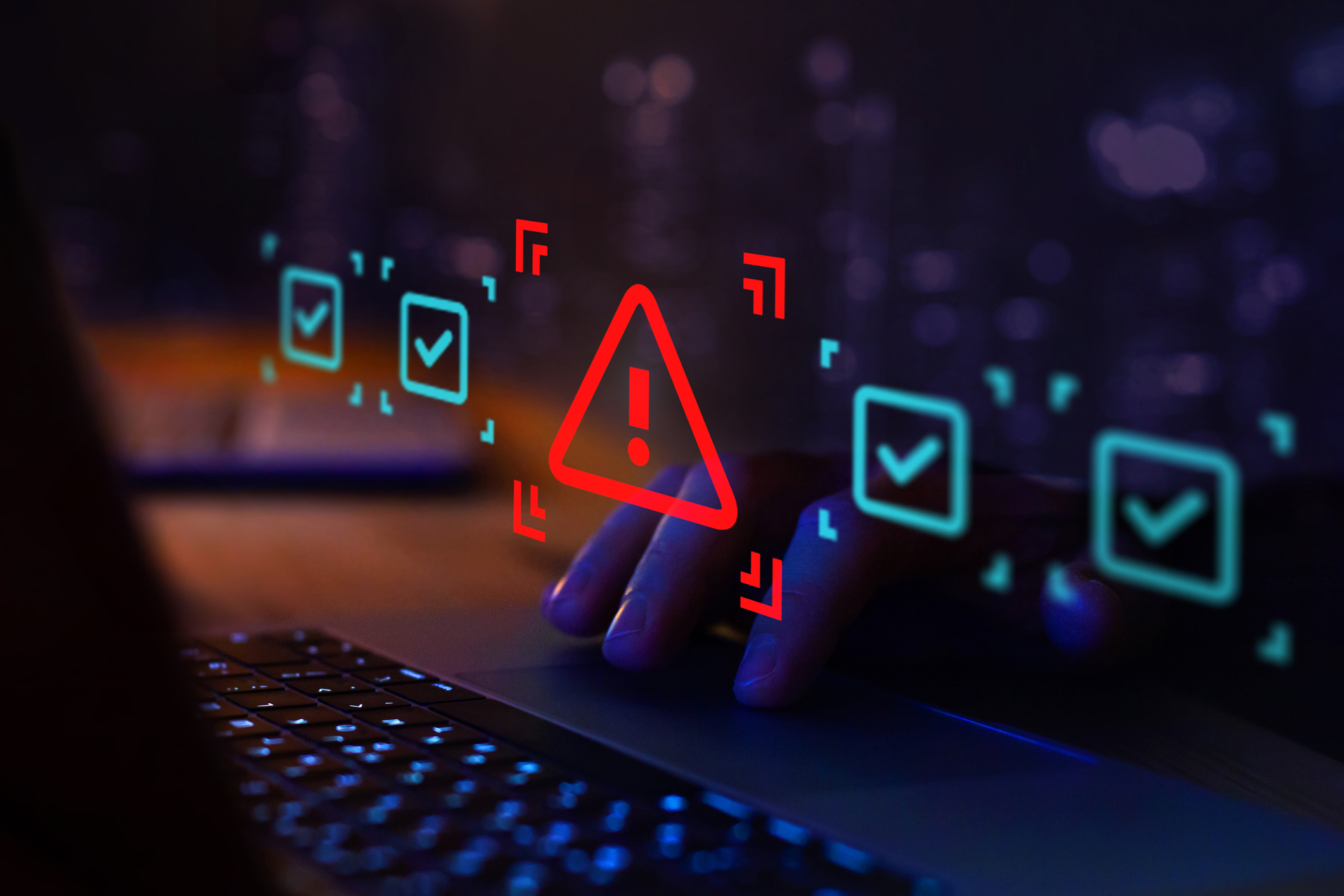 Close-up of a person using a laptop keyboard in a dark, blue-lit environment, with a red warning symbol and floating digital checkmark icons overlaid on the screen, representing cyber security, risk monitoring, or threat detection.